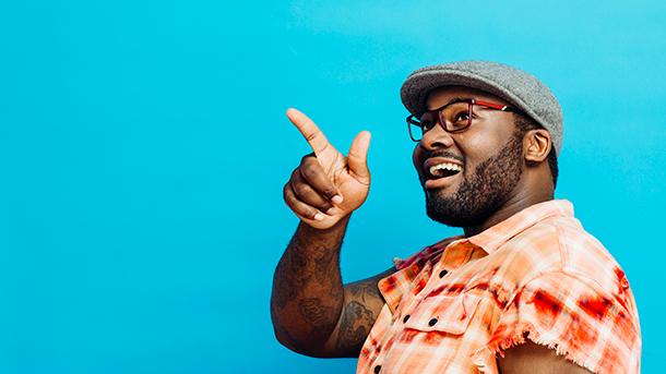 Smiling man pointing on a blue background